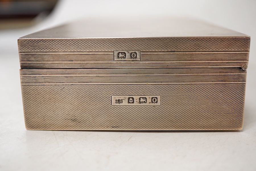 A George VI engine turned silver mounted rectangular cigarette box, by A. Wilcox, Birmingham, 1938, 17cm, with engraved inscription.